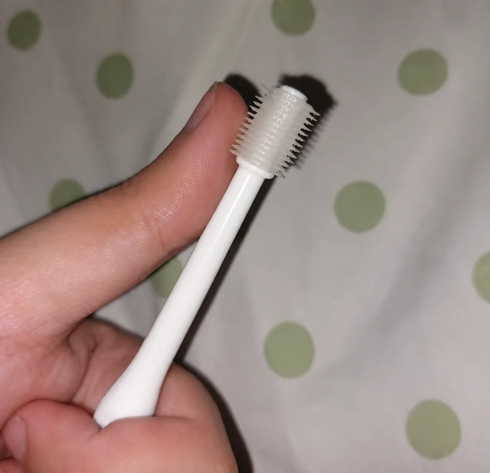 Customer comparing the size of the 360 ToothBrush head to her finger